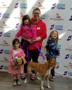 Family with three young children pose with newly adopted dog during Fall in Love Adoption Event.